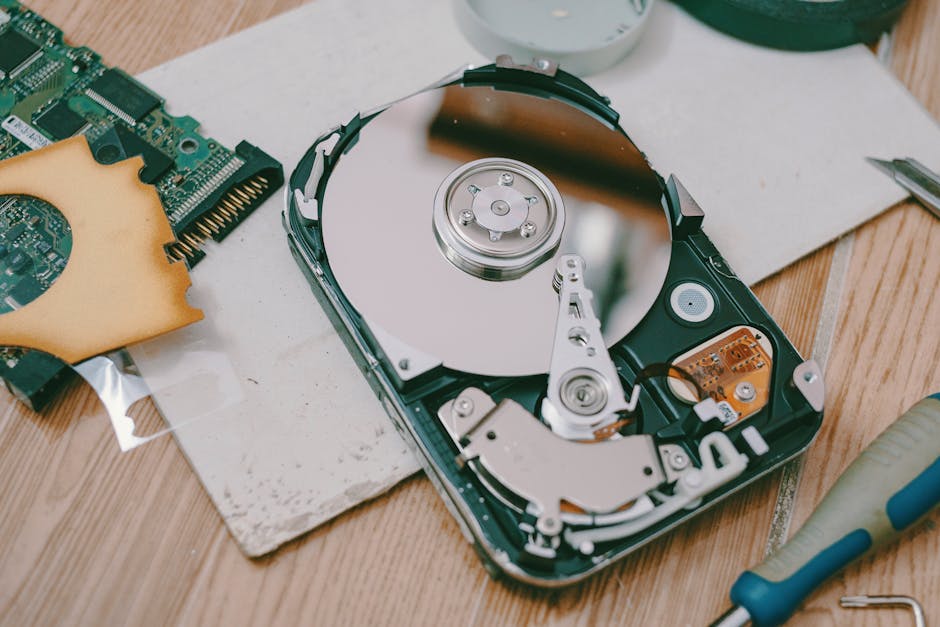 Computer technician using a screwdriver to open a water-damaged computer hard drive